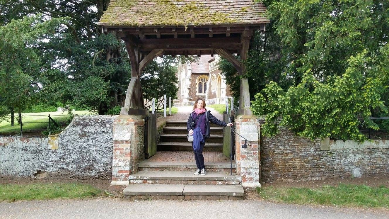 Claire standing at the gate of Sandringham Church.