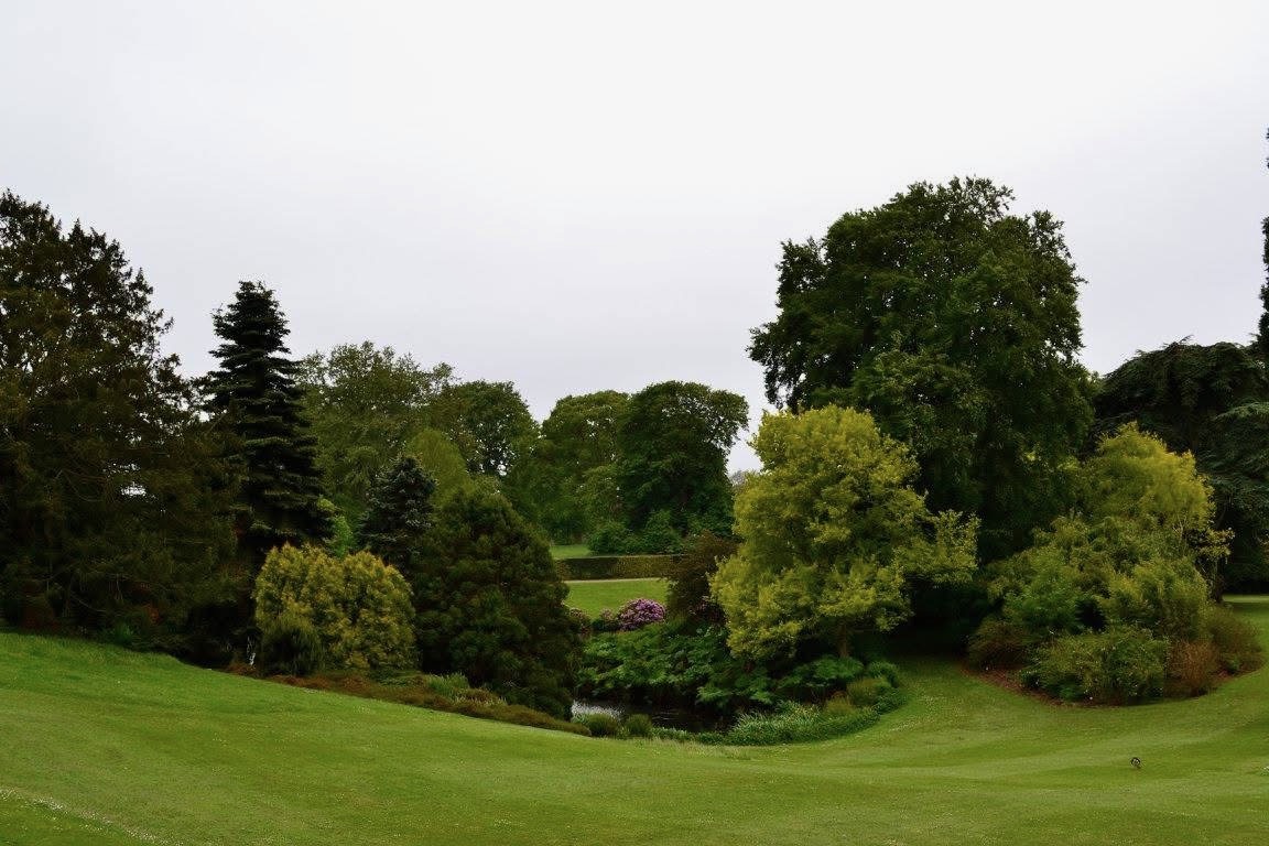 Front lawn of Sandringham House with ornamental trees and lake.
