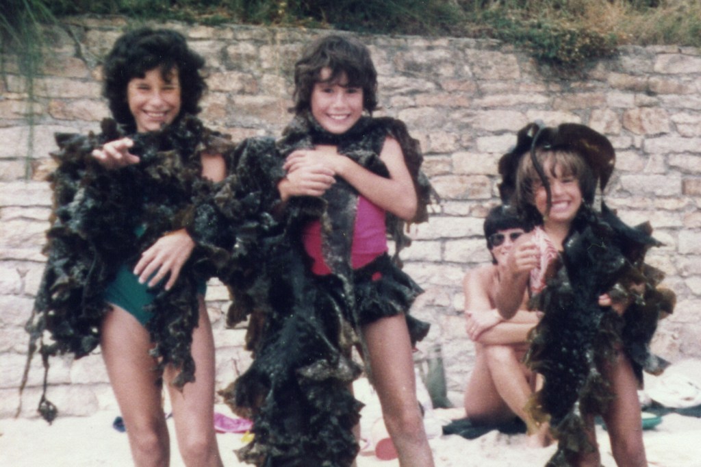 Claire and her sisters as children  covered in seaweed.