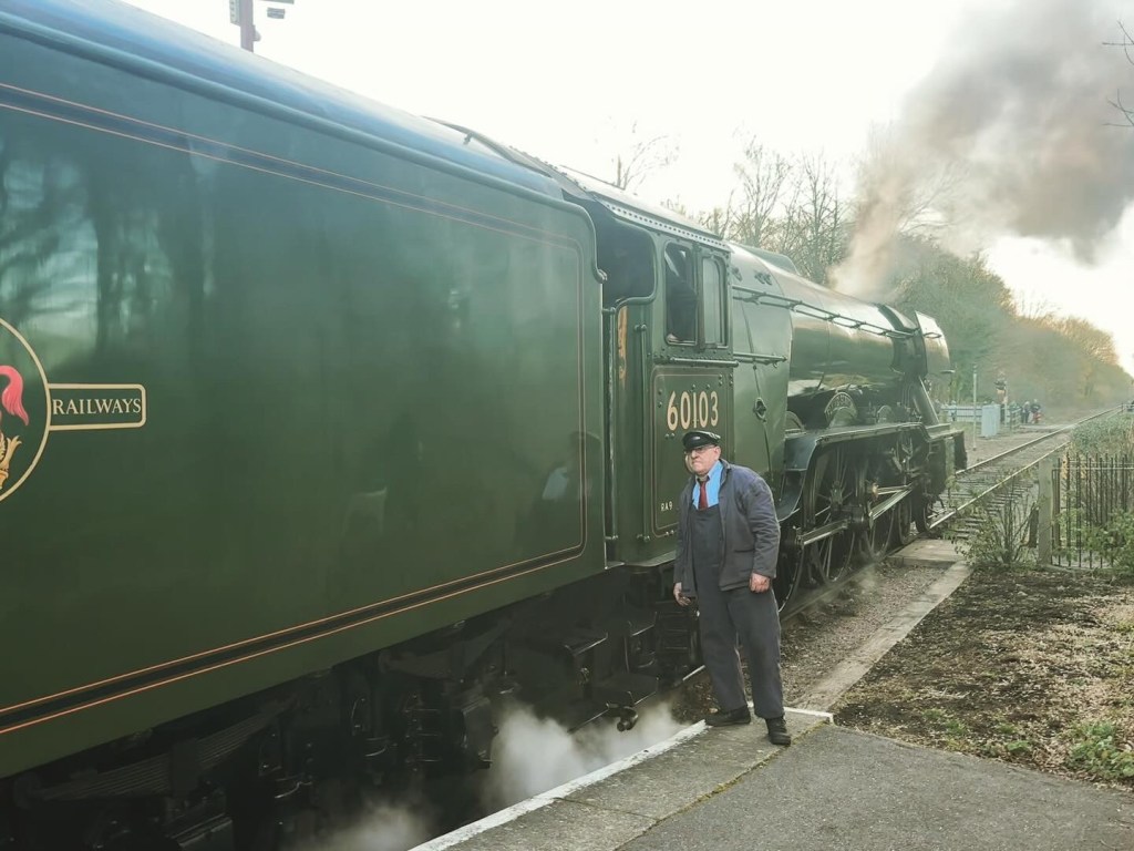 Driver standing next to the Flying Scotsman steam engine.