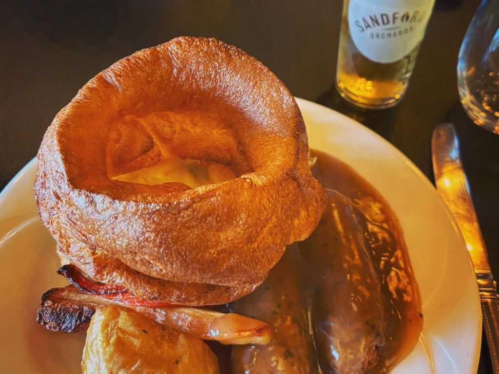 Roast dinner with Yorkshire pudding, veggie sausages and vegetables.