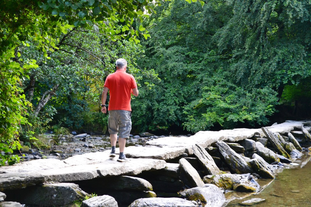Spencer walking across the Tarr Steps - a bridge made of slabs of stone.