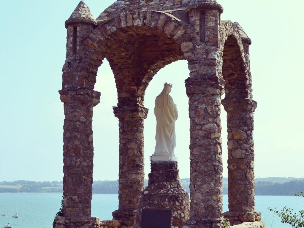 Four pillared shrine with statue looking across the river.