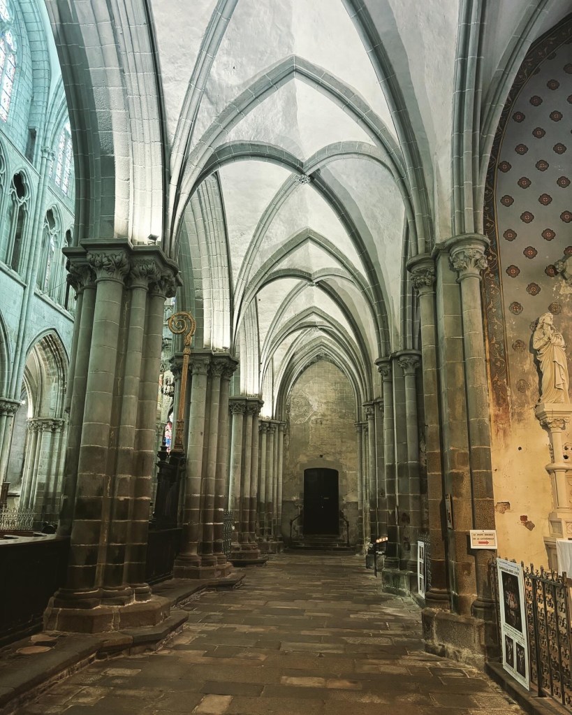Interior of a cathedral with high stone arches and stone floor.