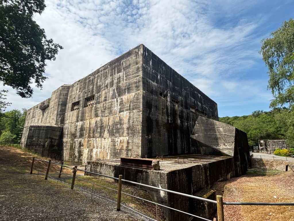 View of the corner of a large old concrete bunker.