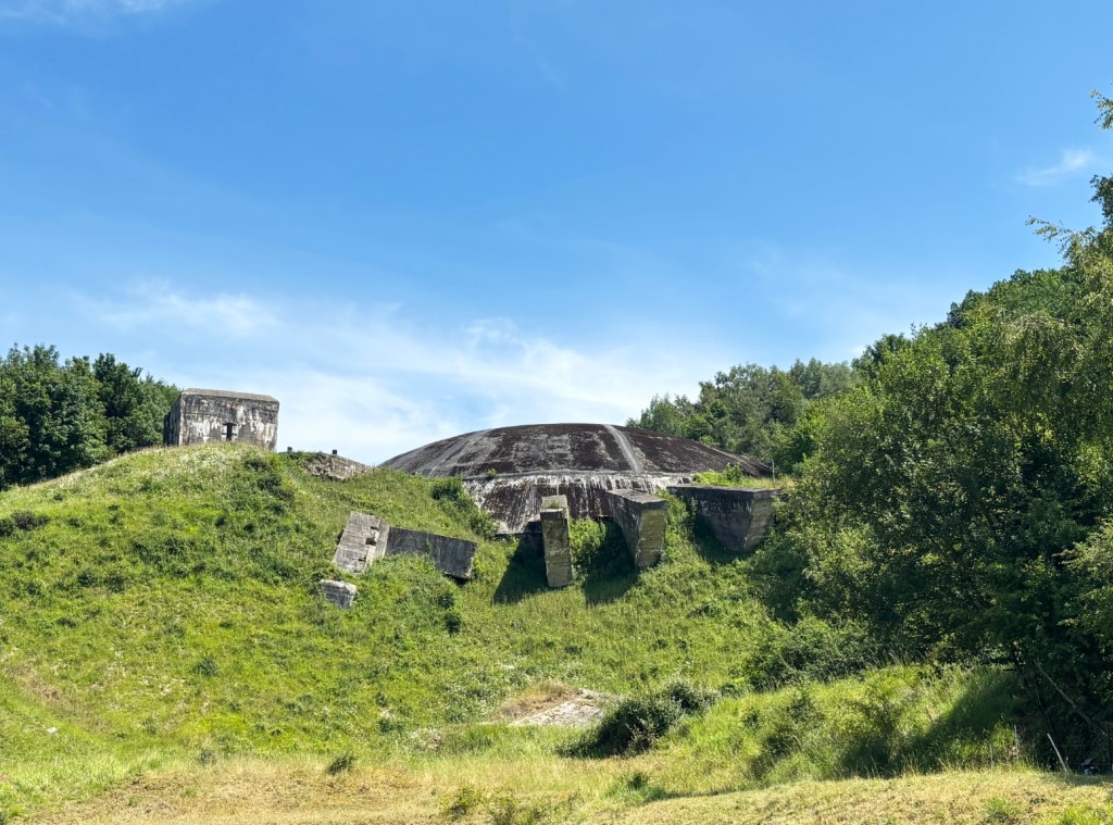 Ruins of concrete dome set into a hillside.