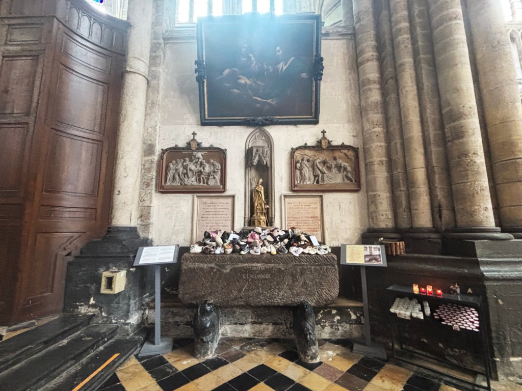 Old stone tomb with shoes piled on top.